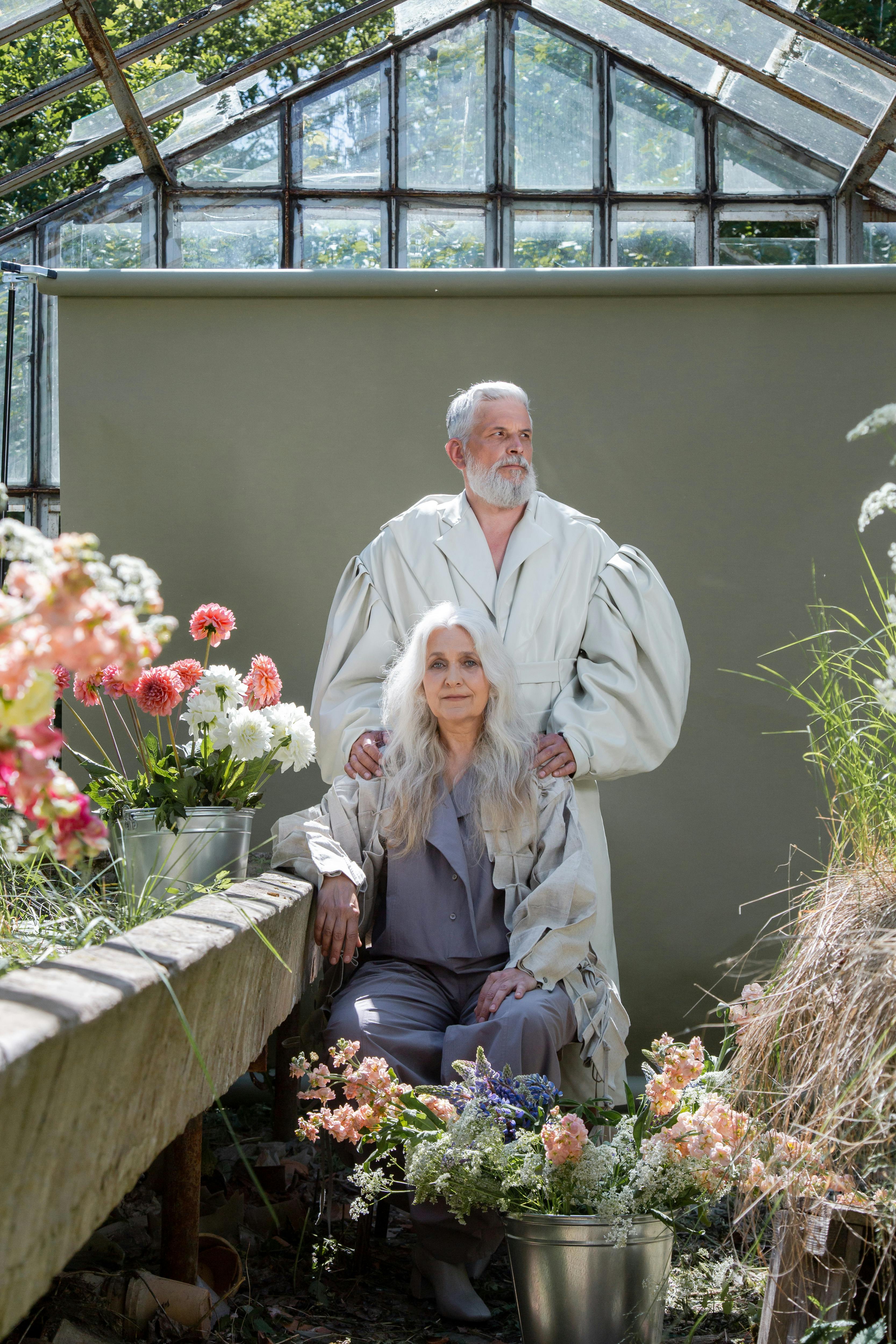 an elderly couple in a greenhouse