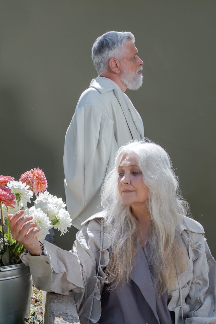 Woman In Gray Long Sleeve Shirt Holding Bouquet Of Flowers