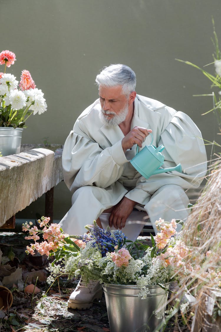 
An Elderly Man Watering Flowers