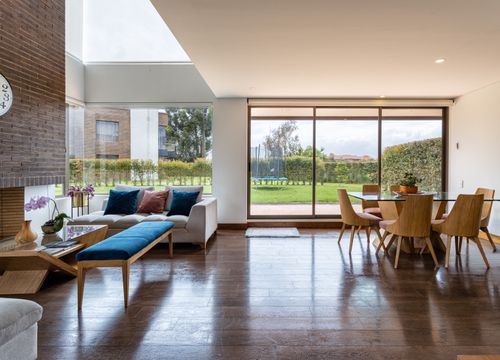 Free Spacious living room with modern decor and large windows showcasing a garden view. Stock Photo