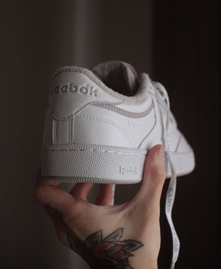 Hand Of A Person Holding A White Rubber Shoe