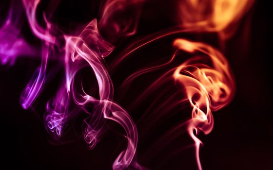 Creative abstract art featuring vivid multicolored smoke swirls on a dark background.