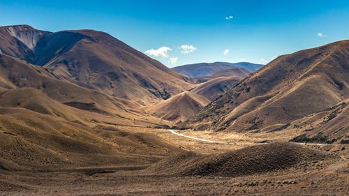 Free Breathtaking view of rolling hills and mountains in New Zealand under a clear blue sky. Stock Photo