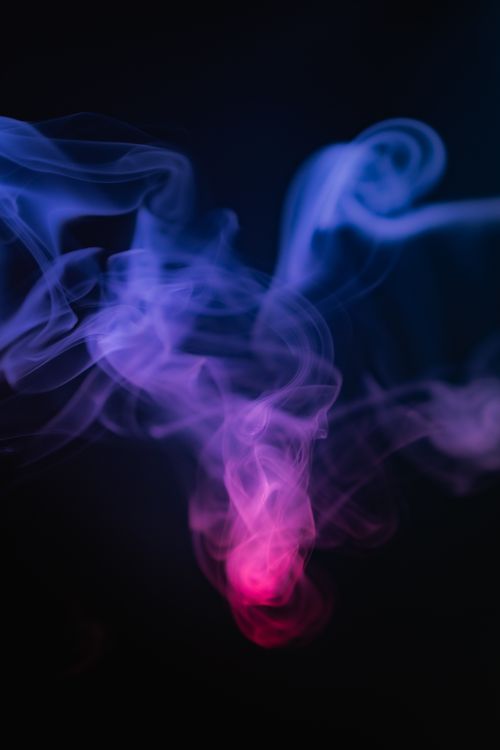 Free Captivating abstract image of swirling blue and red smoke against a black background, creating a mystical atmosphere. Stock Photo