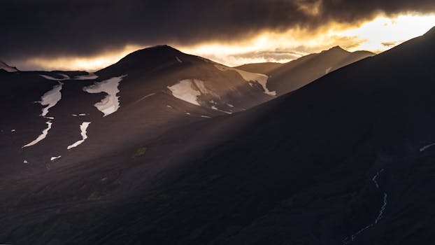 Stunning view of Icelandic mountains at twilight with dramatic lighting and shadows.