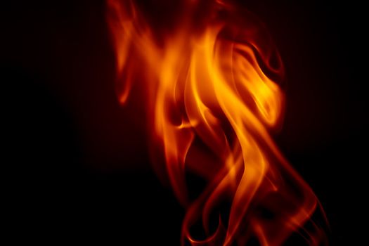 Close-up of vibrant orange flames on a dark backdrop, conveying heat and intensity.