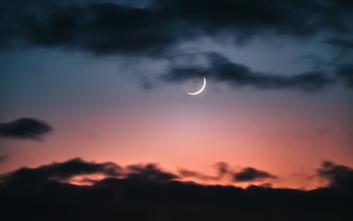 Crescent Moon among Silhouette of Clouds