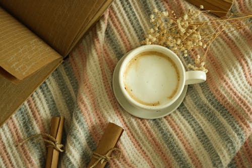 A Cup of Cappuccino on White and Red Striped Textile