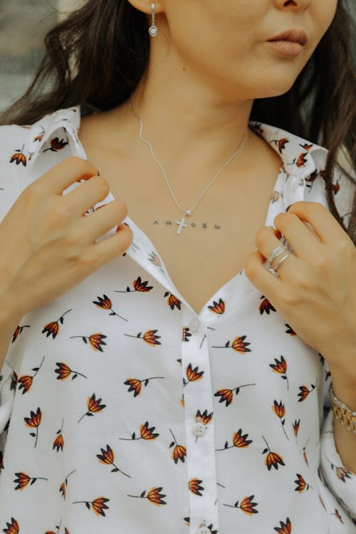 A Woman Wearing a Cross Necklace with Tattoo on Chest