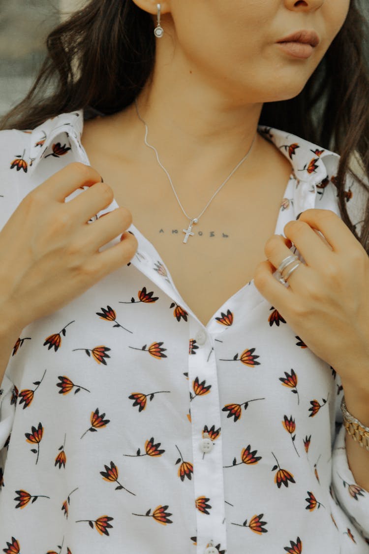 A Woman Wearing A Cross Necklace With Tattoo On Chest