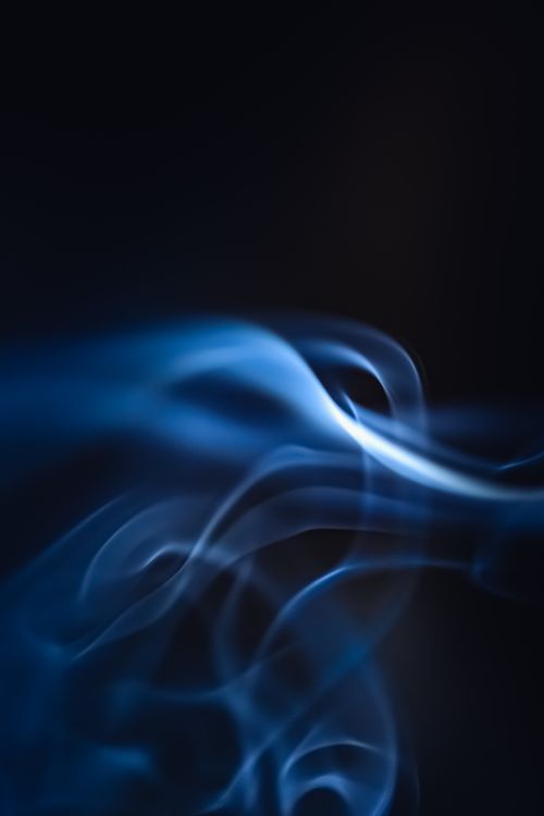 Free A mesmerizing display of soft blue smoke against a black background, creating a mysterious and abstract feel. Stock Photo