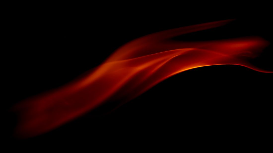 A soft ember-toned flame drifting across a black field — photo by Marek Piwnicki on Pexels