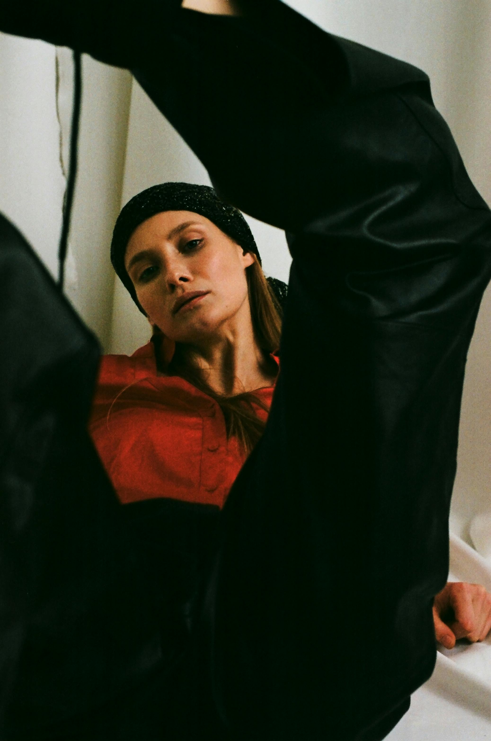 Stylish woman in striking pose with red shirt and black headband, creating a bold fashion statement.