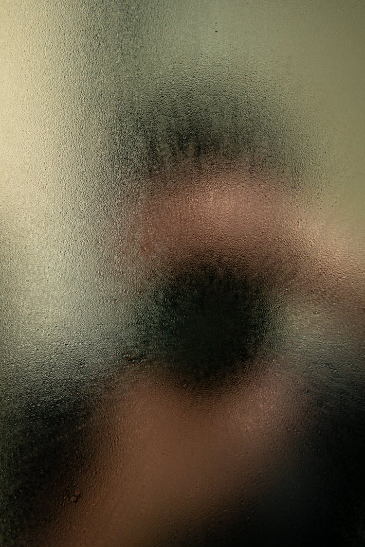 An Eye Of A Person Behind A Blurry Glass