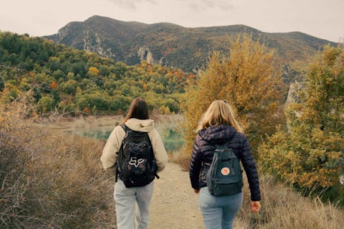 Women Carrying Backpacks Walking Together 