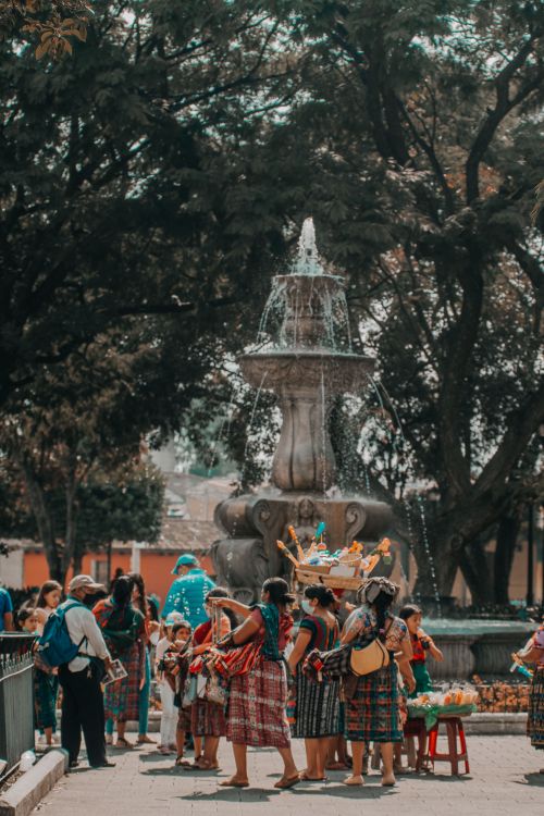 Free Vibrant cultural gathering at the iconic fountain in Antigua Guatemala. Captures local traditions. Stock Photo