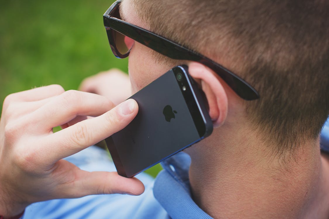 Free Man Putting His Black Iphone 5 on His Left Ear Stock Photo