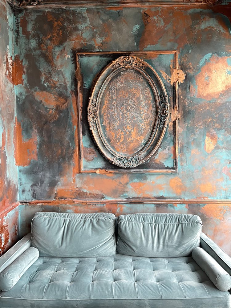 A Couch Near An Oval Wooden Frame On A Wall