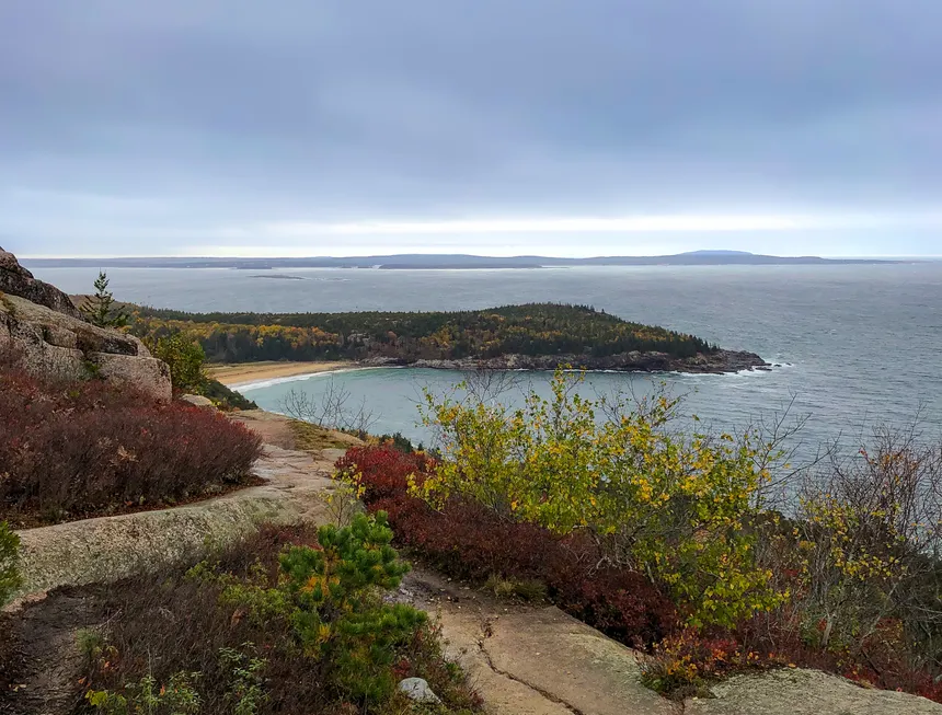 A breathtaking view of Bar Harbor, Maine, with fall foliage and the ocean.