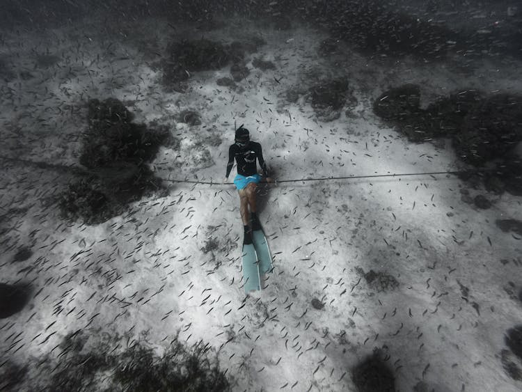 A Person Wearing Flippers And Snorkeling Underwater