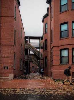A person walks through a brick alleyway in Portland, ME, on a rainy day.