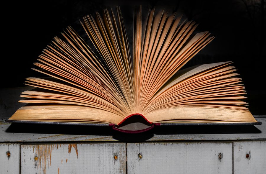 Libro abierto junto a un espejo con luz suave