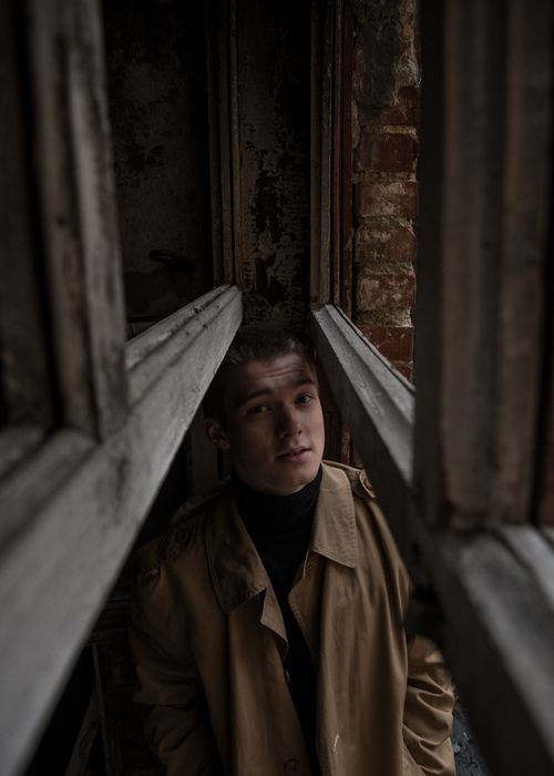 Free A dramatic portrait of a man standing in an abandoned building with selective focus. Stock Photo