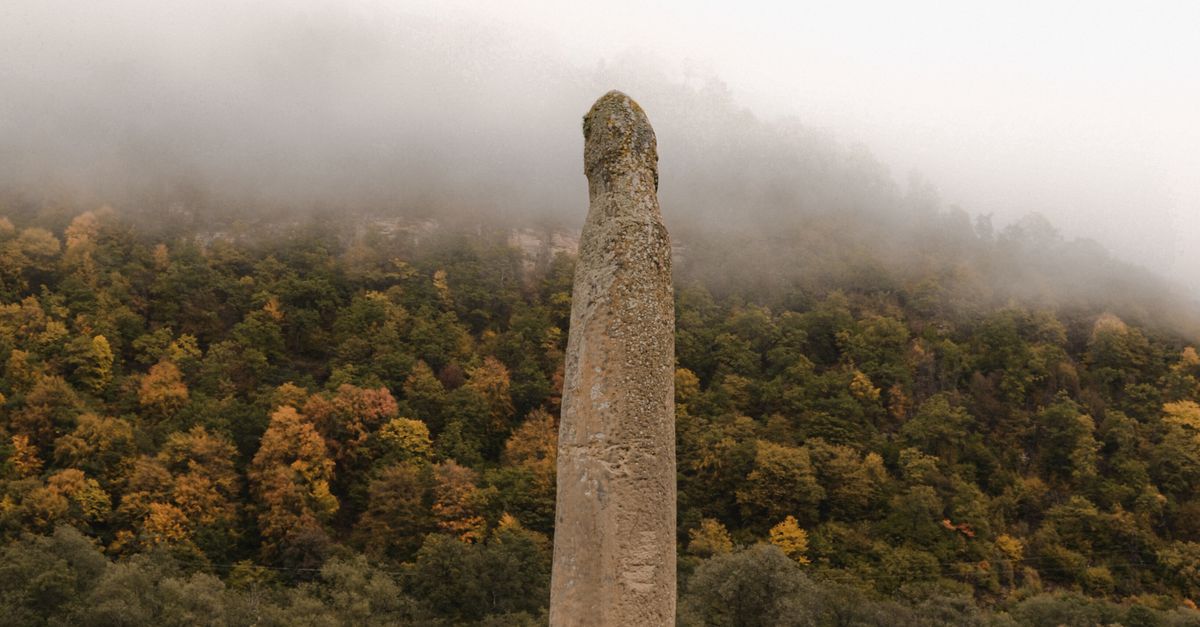 Phallic Shaped Rocks Phallic Rock against Forested Hill · Free Stock Photo