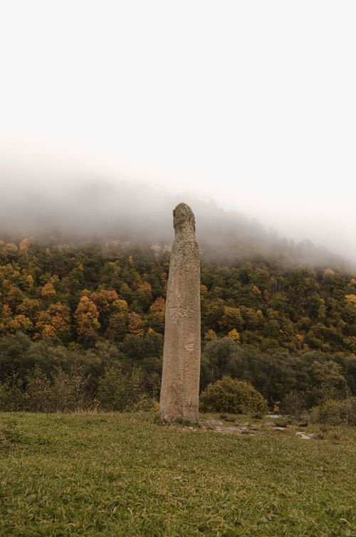 Free Tall stone menhir standing in a foggy forest during autumn in Архыз, Russia. Stock Photo