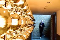 在现代走廊里，模糊的人影与金色球形灯相伴