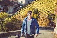 秋日时分，一名身穿蓝色夹克的男子在葡萄园里散步