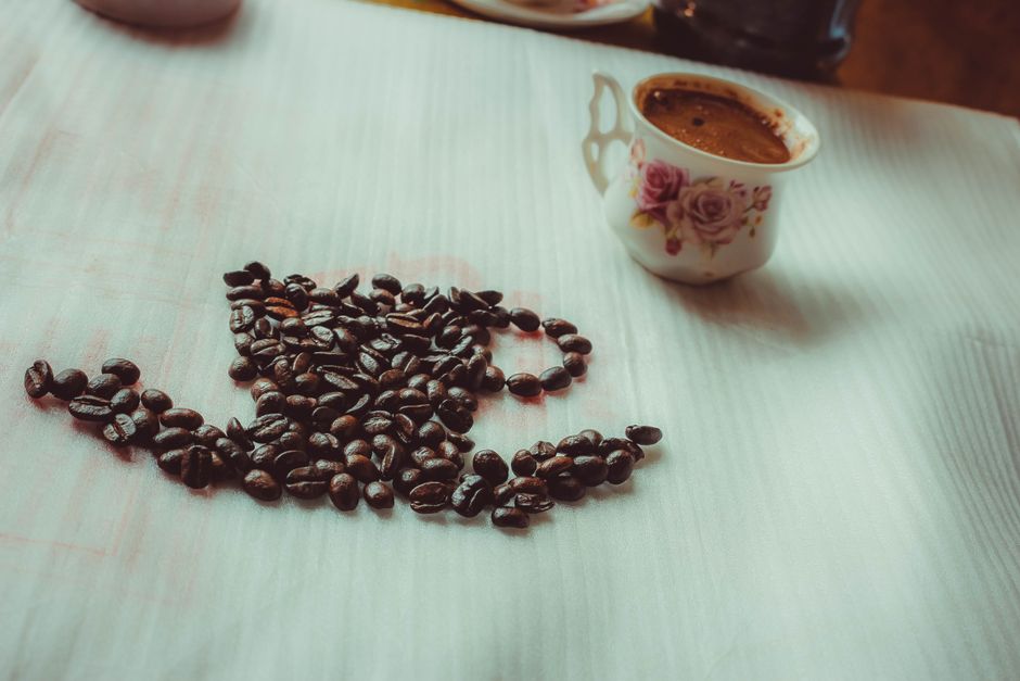 Coffee beans and a cup arranged on a table