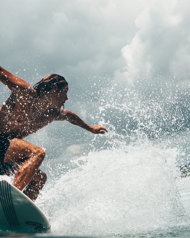 Man Riding White Surfboard