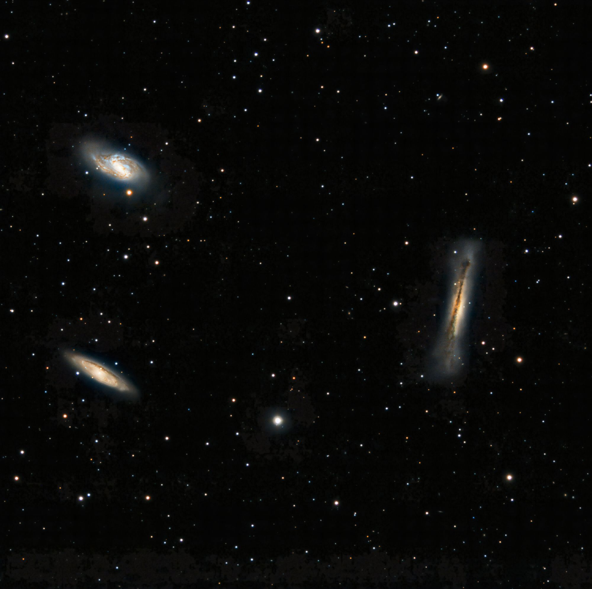 Capture of three distinct galaxies amidst countless stars in the vast cosmos.