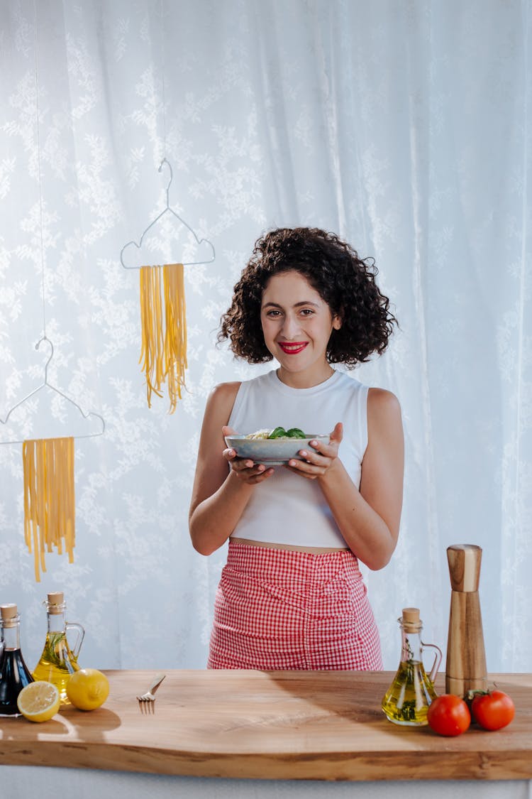 Woman In Kitchen, Holding Bowl With Pasta