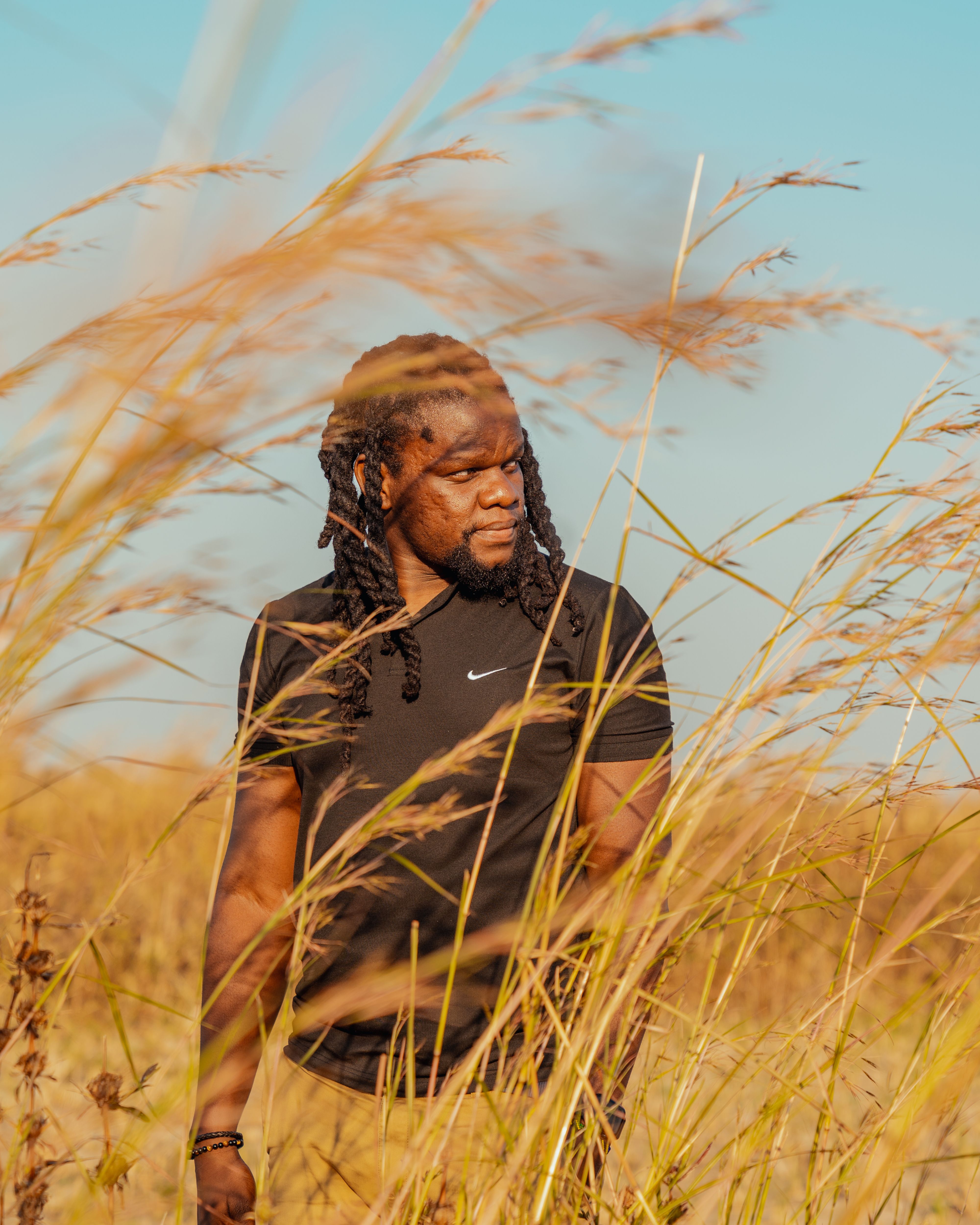 Man Wearing Black Clothing Standing On Green Grass Field · Free Stock Photo