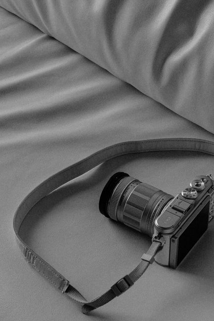 Black and white image of a camera on a smooth surface, showcasing simplicity.