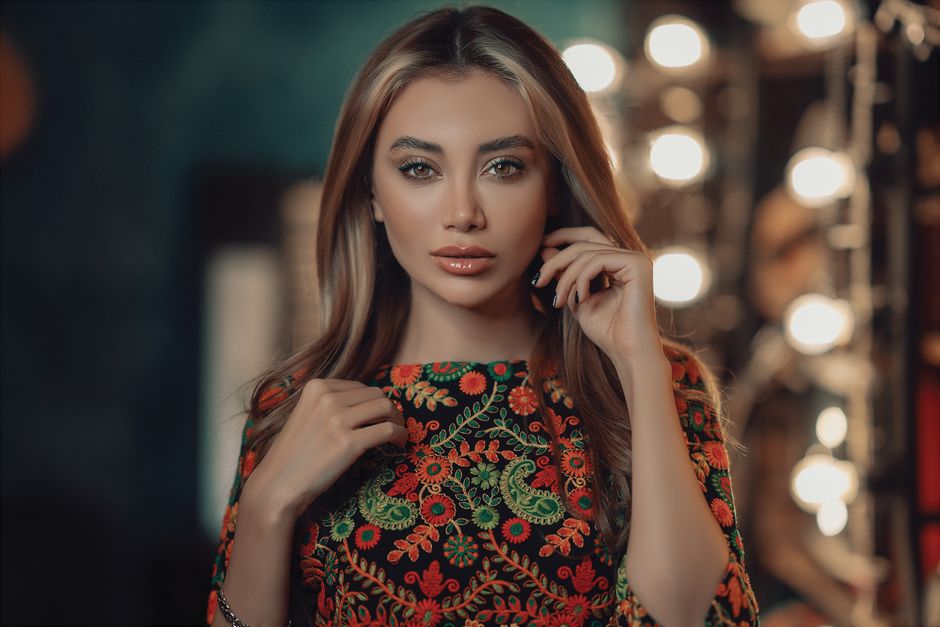 Stunning portrait of a young woman in Tehran, wearing a vibrant floral dress with stylish elegance.