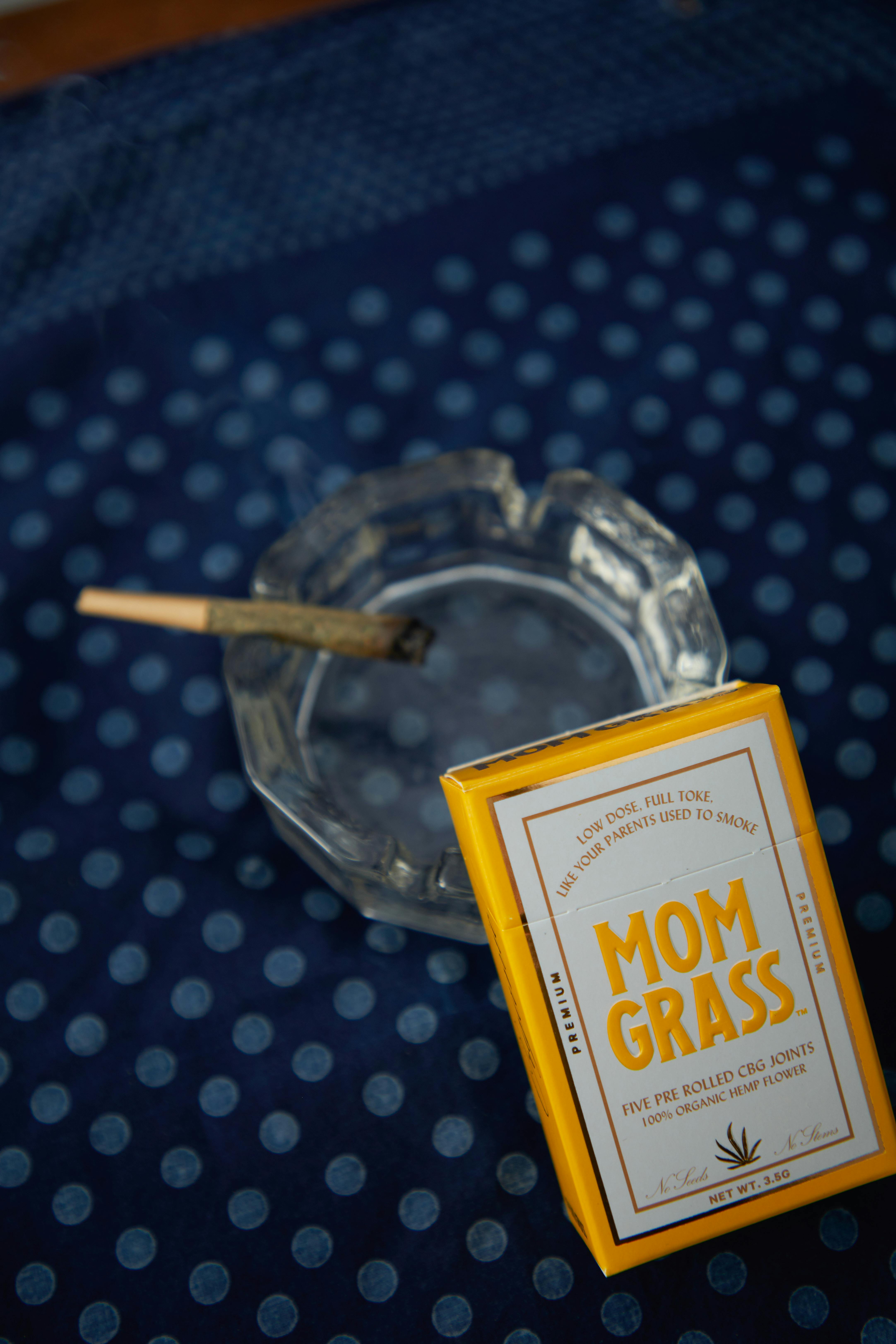 a glass ashtray with cigarette on the polka dot textile