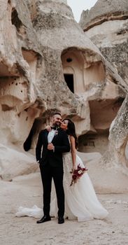 A bride and groom share an embrace amidst stunning rock formations, capturing a unique outdoor wedding moment.