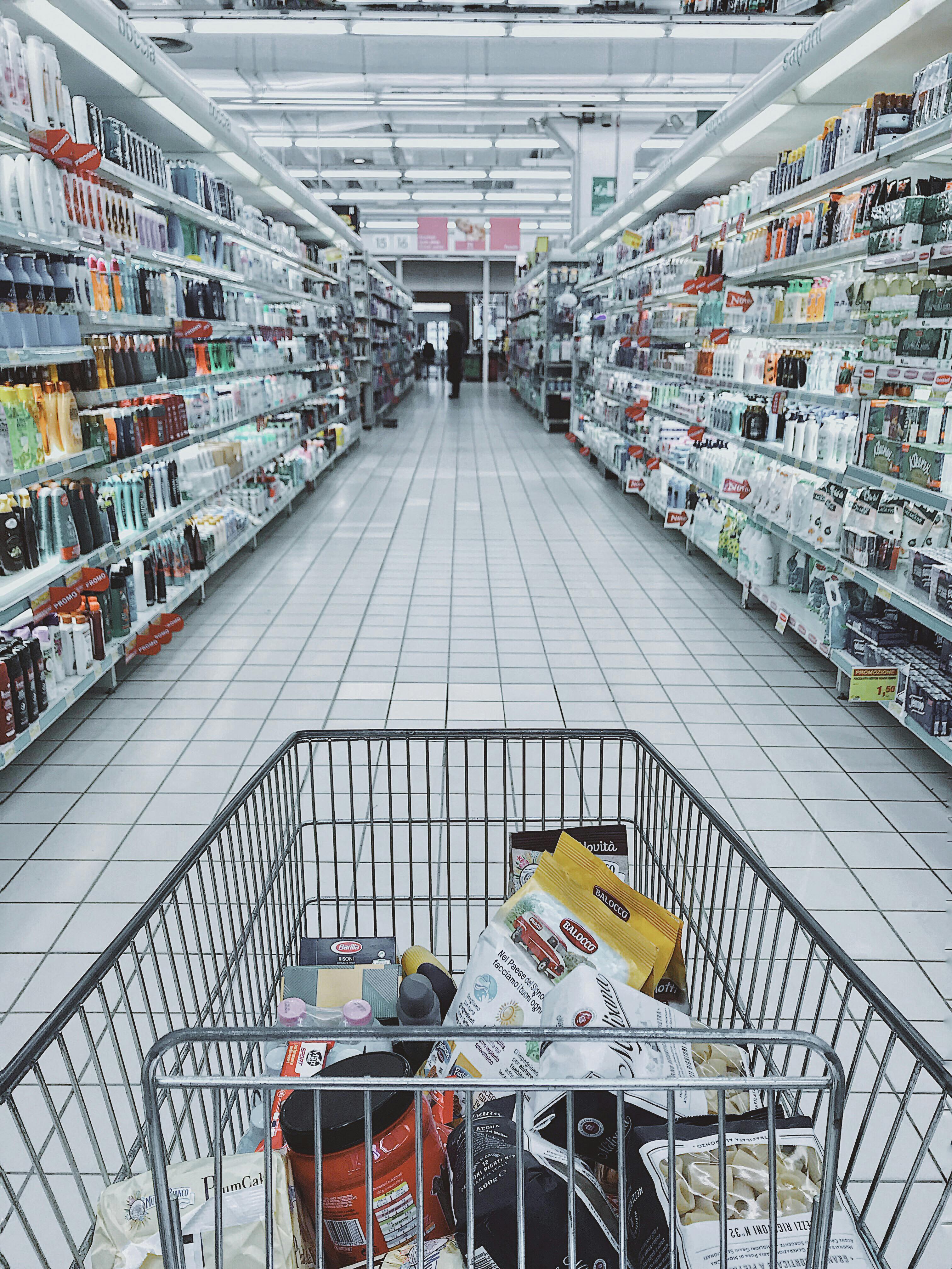 A grocery cart with items in a supermarket. | Photo: Pexels
