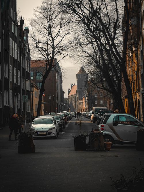 Free Charming street scene in Gdańsk, Poland, featuring parked cars and historic architecture. Stock Photo