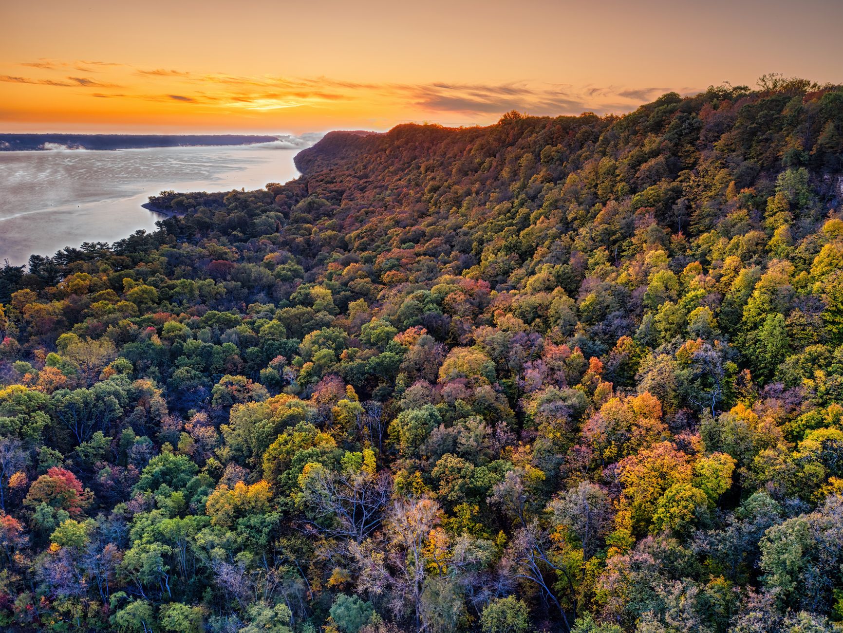 A stunning aerial view of vibrant autumn foliage in a forest near Wacouta, Minnesota at sunrise.