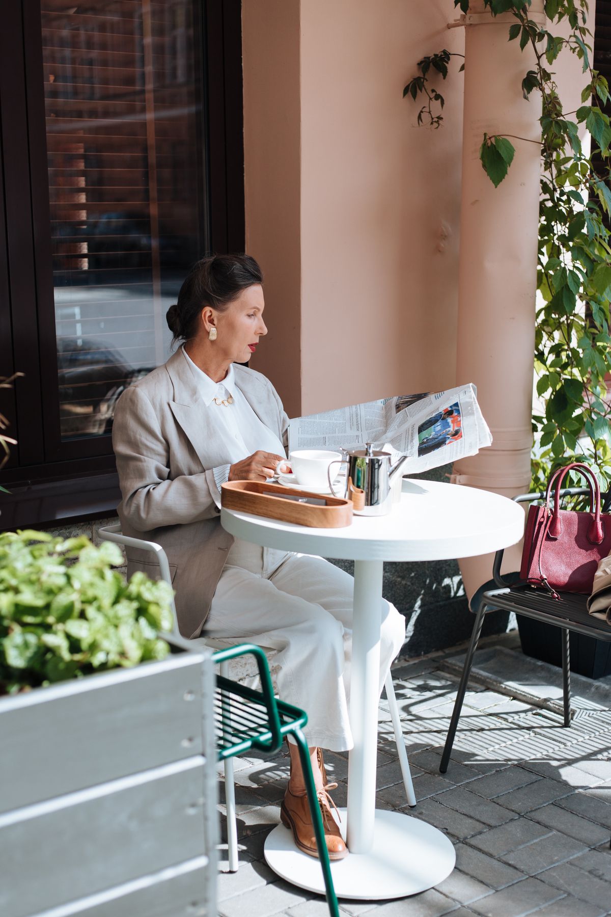 An elegant woman reading the newspaper at a café