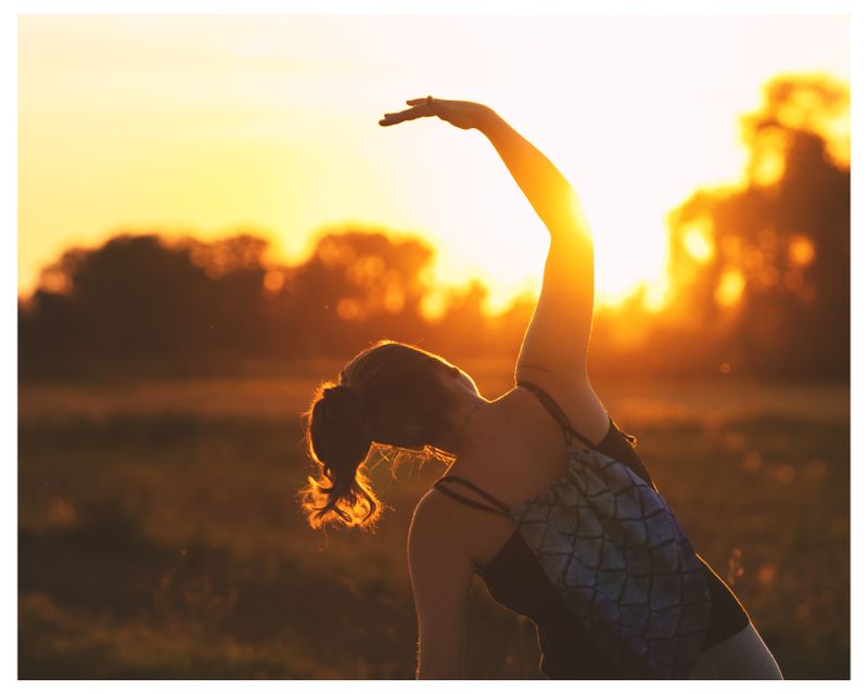 Woman stretching outdoors at sunrise