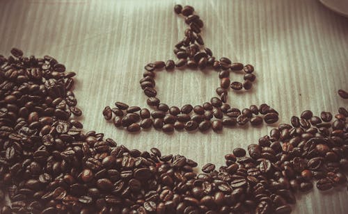Free Brown Coffee Bean Forming Coffee Mug Stock Photo