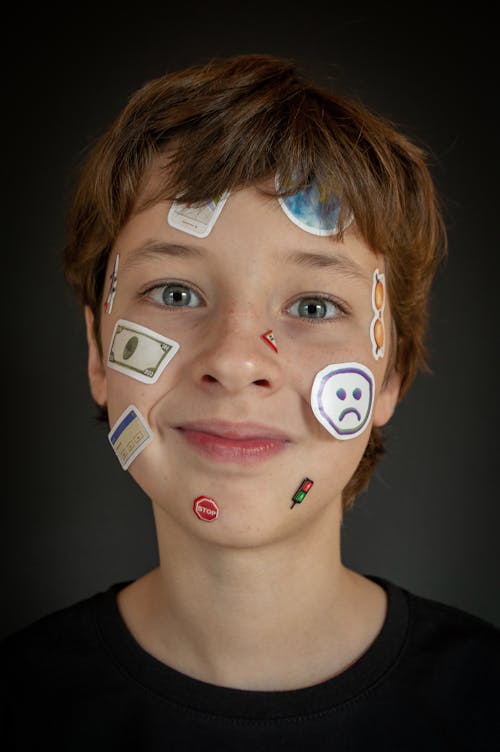 Free A Close-up Shot of a Young Boy with Stickers on His Face Stock Photo