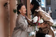 Man in Gray Suit Jacket Kissing Woman in White Dress Holding Bouquet of Flowers