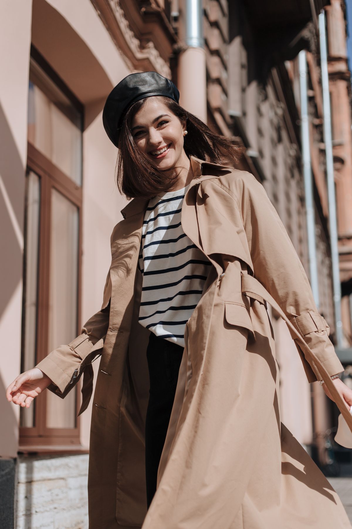 A woman in a brown trench coat, low angle — the timeless trench