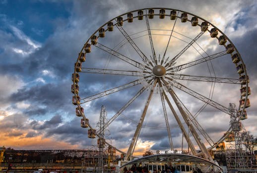 在戏剧性的多云天空背景下，主题公园里的摩天轮令人惊叹